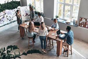 Discussing risky ideas. Top view of two modern young colleagues conducting a business presentation while standing in the board room photo