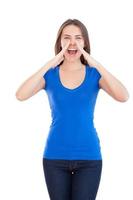 Woman shouting. Beautiful young woman shouting and holding hand near mouth while standing isolated on white photo