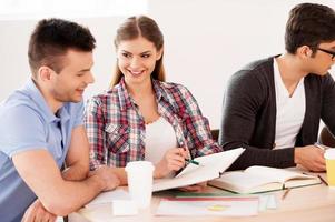 Students studying. Three confident students studying while sitting at the desk together photo