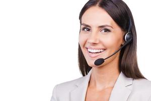 Confident female operator. Beautiful young businesswoman in headset smiling while isolated on white background photo