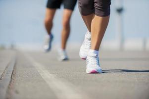 People running.  Close-up image of woman and man running along the running track photo