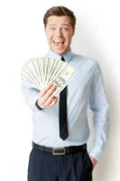 I am so rich Happy young man in formalwear holding money outstretched and expressing positivity while standing isolated on white photo