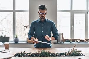 inspirado para trabajar duro. un joven pensativo que trabaja con correspondencia mientras está de pie en la oficina foto