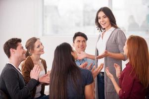 I have an issue. Group of people sitting close to each other while man telling something and gesturing photo
