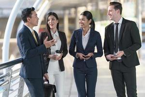 Business people walking and talk to each other in front of modern office photo