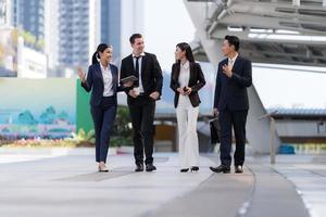 Business people walking and talk to each other in front of modern office photo