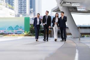 Business people walking and talk to each other in front of modern office photo