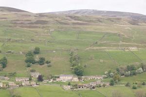 a Yorkshire Dales village with hills and fields photo