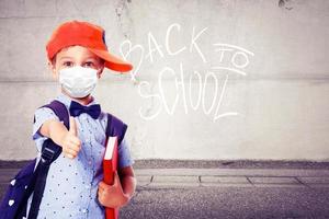 Young boy with protection mask against corona virus at school. photo