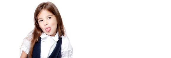 Portrait of cute smiling schoolgirl shows tongue, isolated on white background. photo