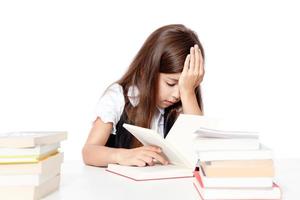 Tired little child girl sleeping on the desk at school. photo