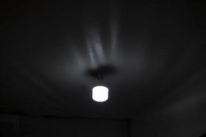 Lamp on ceiling. Dim light in room. Lighting device. photo