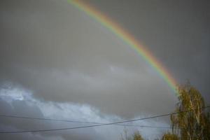 Rainbow in sky. Beautiful weather. Decomposition of light into colors. photo