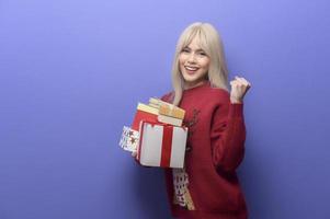 retrato de una joven caucásica feliz con una caja de regalo sobre un fondo morado foto