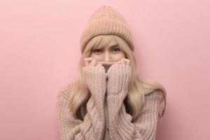 retrato de una joven caucásica con suéter sobre fondo rosa foto