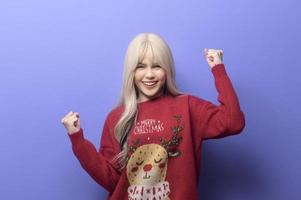 Portrait of happy Caucasian young woman  with gift box over purple background photo