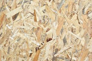 Texture of yellow wooden OSB plate close up photo