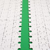 The green path is laid on the platform of a white folded jigsaw puzzle. Texture image with copy space for text photo