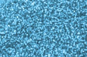 Blurred blue decorative sequins. Background image with shiny bokeh lights from small elements photo