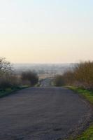 Dawn in the village. Asphalt road, leaving far into the distance among the fields photo