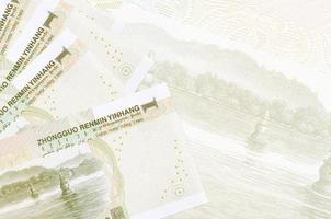 1 Chinese yuan bills lies in stack on background of big semi-transparent banknote. Abstract business background photo