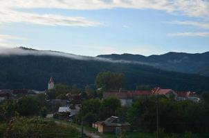 The apartment building is in front of a thick layer of fog. Living in a mountainous area in the Carpathians, Ukraine photo