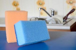 A few sponges lie on the background of the sink with dirty dishes photo