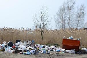 The garbage can is packed with garbage and waste. Untimely removal of garbage in populated areas photo