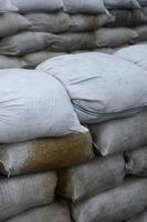 fondo de muchas bolsas de arena sucias para la defensa contra inundaciones. barricada protectora de sacos de arena para uso militar. hermoso búnker táctico foto