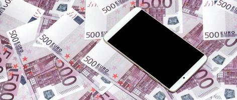 Purple 500 euro money bills and a smartphone with black screen. Copy space. The concept of online banking, money management and shopping with modern technology photo