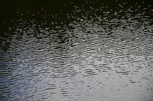 The texture of dark river water under the influence of wind, imprinted in perspective. Horizontal image photo