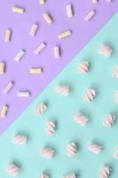 Colorful marshmallow laid out on violet and blue paper background. pastel creative textured pattern. minimal photo