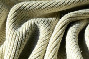 Fabric texture of a soft yellow knitted sweater. Macro image of the structure of bindings in yarns photo