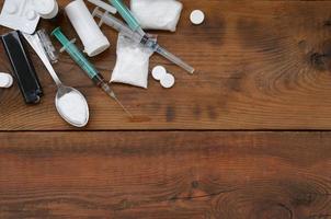 A lot of narcotic substances and devices for the preparation of drugs lie on an old wooden table photo