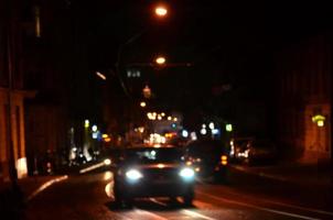 Blurred night scene of traffic on the roadway. Defocused image of cars traveling with luminous headlights. Bokeh Art photo