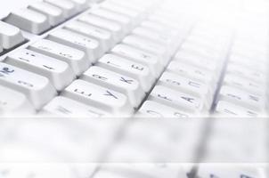 Close-up of the white computer classic keyboard with english and russian letters with copy space field photo