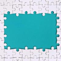 Framing in the form of a rectangle, made of a white jigsaw puzzle around the blue space photo