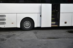 autobús turístico blanco para excursiones. el autobús está estacionado en un estacionamiento cerca del parque foto