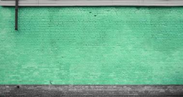 The texture of the brick wall of many rows of bricks painted in green color photo