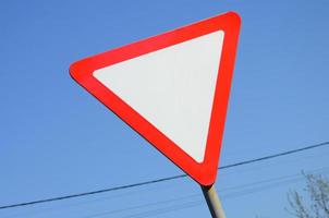 Traffic sign in the form of a white triangle. Give way photo