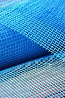 Close-up texture of a blue reinforcing mesh rolled up in a roll. Building resource for reinforcing walls in the process of their warming photo