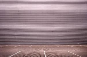 Empty parking spaces on the background of a metal wall with space for product placement photo