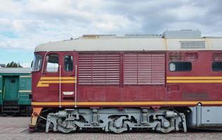 Cabin of modern Russian electric train. Side view of the head of railway train with a lot of wheels and windows in the form of portholes photo