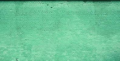 The texture of the brick wall of many rows of bricks painted in green color photo