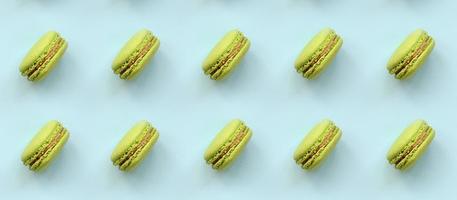 Green dessert cake macaron or macaroon on trendy pastel blue background top view. Flat lay pattern composition photo