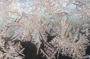 Snowflakes frost rime macro on window glass pane photo