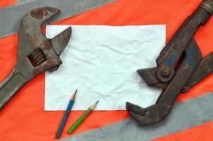 Adjustable wrenches and a sheet of paper with two pencils photo