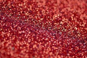 Crimson red decorative sequins. Background image with shiny bokeh lights from small elements photo