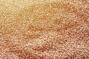 Background texture of a large pile of buckwheat. Many buckwheat grains close-up in daylight photo