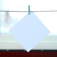 White blank card on rope, window glass background. Creative reminder, small sheet of paper on wooden clothespin, memo backdrop photo